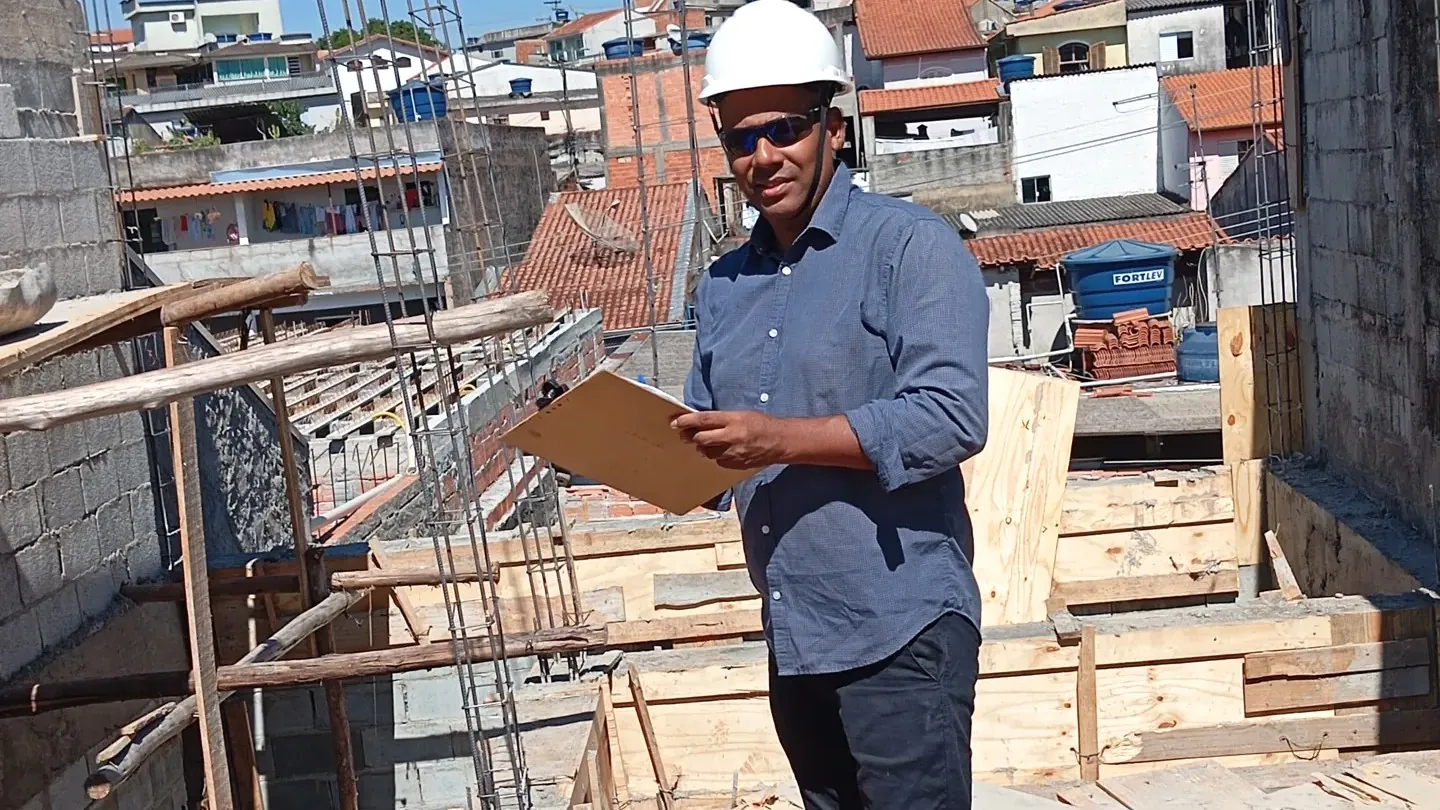 Engenheiro com prancheta acompanhando obra em execução
